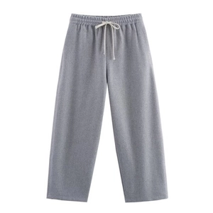 Detail of grey knitted joggers featuring elastic drawstring waistband and soft fabric texture