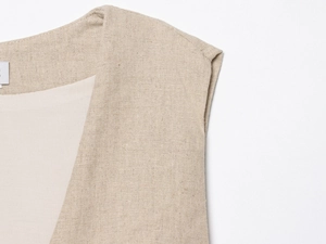 Detail of oatmeal textured beaded vest showing premium linen fabric and V-neck stitching