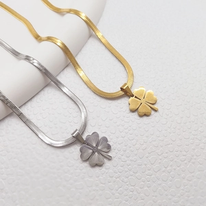 Golden and silver four-leaf clover necklaces with herringbone chains on a white base