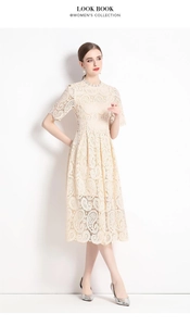 Detail der eleganten beigen Spitzenstickerei und Blumenmuster am ausgestellten Kleid