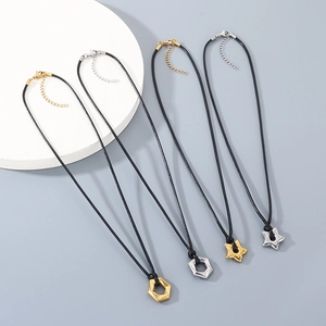 Close-up of geometric star and hexagon pendants on black cords in gold and silver