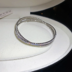 Gros plan d'un bracelet croisé argenté à plusieurs rangs avec pavage de zircons brillants