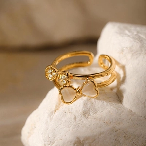 Double-layered gold bow ring with rhinestones and opal on a natural rock