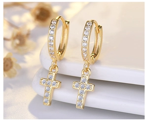 Macro shot of gold cross drop earrings with sparkling pavé cubic zirconia inlay detail