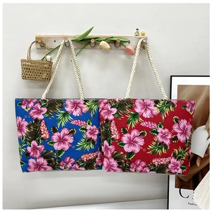 Close-up of printed canvas tote bags with hibiscus patterns and hemp rope handles