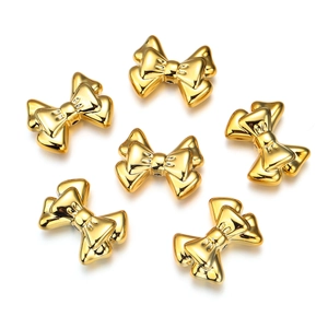 Close-up of golden double-layered acrylic bow beads for DIY jewelry and hair accessories