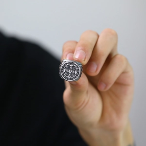 Detailed macro view of vintage stainless steel Saint Benedict cross ring with relief texture