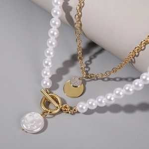 Macro detail of multi-layer pearl necklace with gold chain and baroque pearl pendant