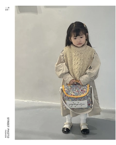 Detailed view of floral kids crossbody bag with yellow trim and wide white shoulder strap