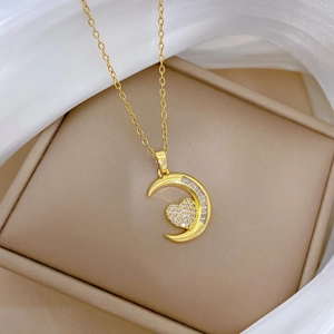 Dettaglio del ciondolo a luna e cuore dorato con diamanti in scatola regalo