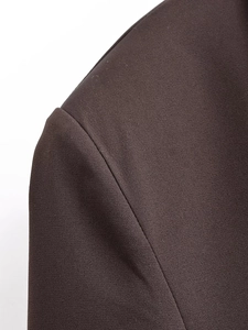 Detail shot of chocolate brown double-breasted blazer showing fine twill fabric and shoulder seams