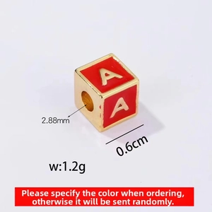 Detailed macro view of a red enamel square alphabet spacer bead with gold letter A