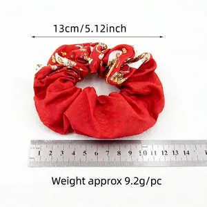 Red Christmas velvet scrunchie with print, 13cm diameter shown with scale measurement