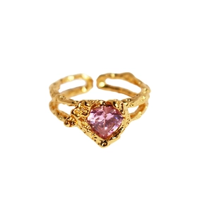 Gold open ring with pink heart gemstone and textured band on white background