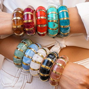Colorful geometric acrylic resin bangles with gold metal rings on a model's arm