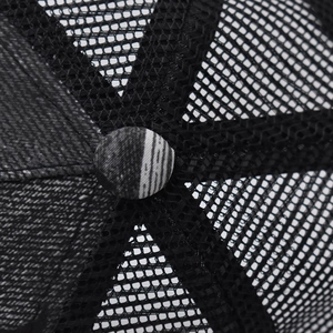 Detail shot of the breathable mesh crown and top button of a stylish trucker hat
