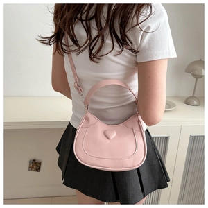 Rear view of a model wearing a pink heart-shaped crescent bag with adjustable straps