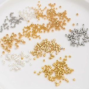 Macro detail of various gold and silver metal beads for DIY jewelry making in a bowl