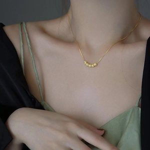 Minimalistische Goldkette mit fünf polierten Perlen an einer feinen Kette für Damen