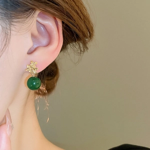 Nahaufnahme von Vintage-Harzperlenohrringen mit strukturierter Vergoldung am Model