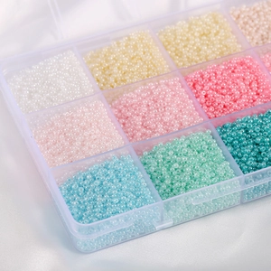 Macro shot of colorful pastel macaron glass seed beads in a transparent plastic storage box