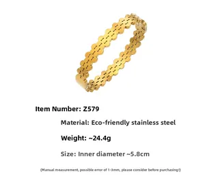 Detail of a gold stainless steel geometric bangle with linked solid rings and 5.8cm diameter