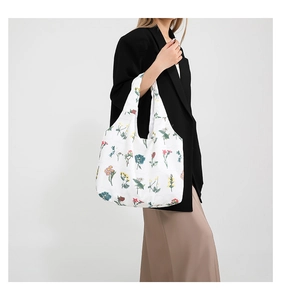 Detail of white tote bag with colorful floral prints and eco-friendly canvas texture
