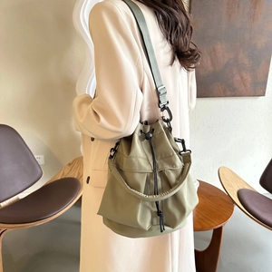 Gros plan du sac seau en nylon vert olive avec cordon de serrage et bandoulière