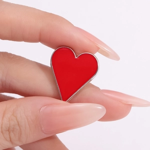Minimalist red heart poker enamel pin brooch with silver metal trim on hand