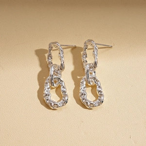 Vue détaillée des boucles d'oreilles argentées à maillons entrelacés avec texture métal