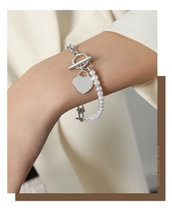 Detail of French style pearl and silver chain bracelet with heart charm and OT clasp