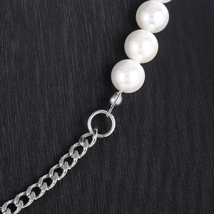 Close-up of pearl and titanium steel chain necklace showing polished textures