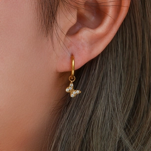 Gold-plated hoop earrings with zircon butterfly charms worn by a model