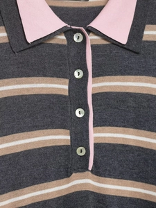 Detail of pink polo collar and pearlescent buttons on striped knit sweater