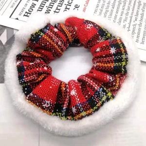 Detail of red tartan Christmas scrunchie with white faux fur trim and snowflake pattern