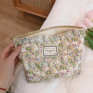 Close-up of floral canvas pouch with a TIME TO PARTY label and zipper detail