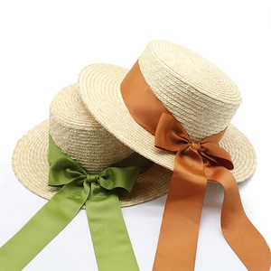 Détail de chapeaux de paille avec de larges rubans élégants en satin et nuds décoratifs