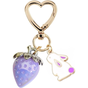 Close-up of strawberry and rabbit charms with golden heart-shaped clasp keychain