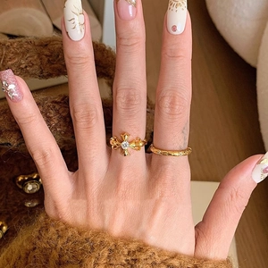 Vintage gold iris cross ring with zircon inlay shown on model with warm aesthetic