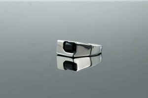 Macro view of men's brushed silver ring featuring a rectangular black zircon gemstone