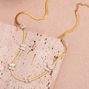 Detail of 18K gold-plated snake chain necklace with white shell butterfly charms