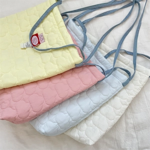 Detailed quilted heart patterns on colorful messenger bags with denim straps