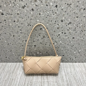 Close-up of beige woven leather shoulder bag featuring intricate knot and golden zipper