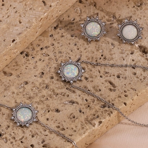 Detail of silver sunburst necklace and earrings set with white opal and clear zircons
