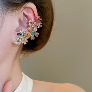 Detail of 18k gold plated flower ear cuff with colorful rhinestones worn on ear
