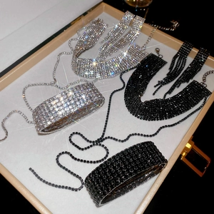 Gros plan d'ensembles de colliers et bracelets en strass argent et noir en coffret
