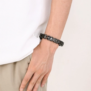 Detail of men's black industrial chain bracelet with carbon fiber inlay on wrist