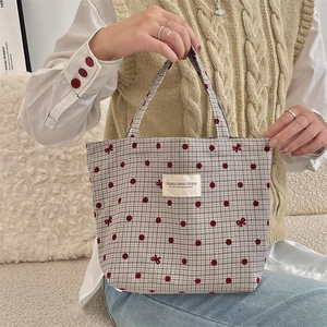 Gros plan d'un sac Zakka japonais à pois rouges avec un nœud brodé élégant