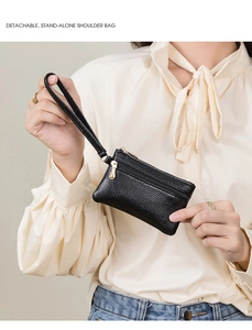 Close-up of black litchi pattern coin purse with dual zippers and wristlet strap