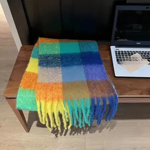 Detail of colorful rainbow plaid scarf featuring thick knit texture and long tassels